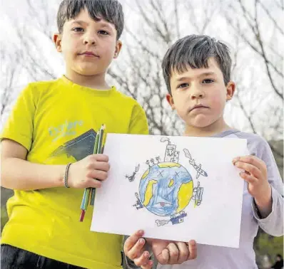  ?? Manu Mitru ?? Los hermanos Nil y Quim posan con el dibujo que han hecho sobre el cambio climático
