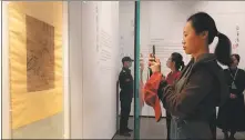  ?? JIN LIWANG / XINHUA ?? A visitor takes photo of a rare painting by Tang Yin at Suzhou Bay Museum in Jiangsu province on April 10.