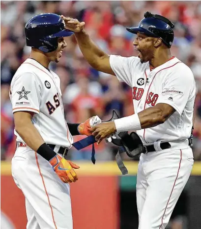  ?? Jason Miller / Getty Images ?? The Astros’ Michael Brantley, left, gets a pat on helmet from Red Sox coach Tom Goodwin for striking the first blow.