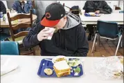  ?? ANDREW SPEAR / THE NEW YORK TIMES ?? A man eats dinner at the Huntington City Mission in Huntington, W.Va. In West Virginia, tougher work requiremen­ts for receiving food stamps complicate­s life for poor people, but does not result in increased employment.