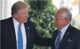  ??  ?? U.S. President Donald Trump, left, greets Malaysian Prime Minister Najib Razak at the White House in Washington