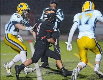  ?? DANA JENSEN/THE DAY ?? Montville’s Sam Kury (4) splits Ledyard defenders Max Ebdon (10) and Austin Brandt (17) for one of his three touchdowns during the Indians’ 40-0 victory on Friday night.