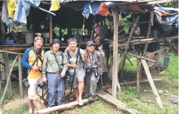  ??  ?? Hon Choon Kim (second left) during one of his numerous trips to Penan villages with his photograph­er friends.