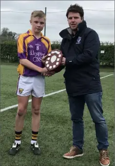  ??  ?? Cian Doyle is presented with the shield by Tadhg Doran.