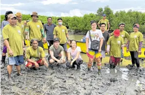  ?? ?? Mangrove Movement founder Uy and vice president Bea Tan with the Noveleta river rangers after a day of planting