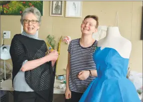  ??  ?? Five Points Gallery Executive Director Judith McElhone joins “Launch Pad” artist Rose Orelup, who creates fabric design using recycled materials. The blue dress is made from hospital bedding.