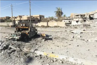  ?? Khalid Mohammed / Associated Press ?? A demolished armored vehicle sits amid the devastatio­n in Ramadi, 70 miles west of Baghdad. More than 60 percent of the city has been destroyed in fighting with the Islamic State group.