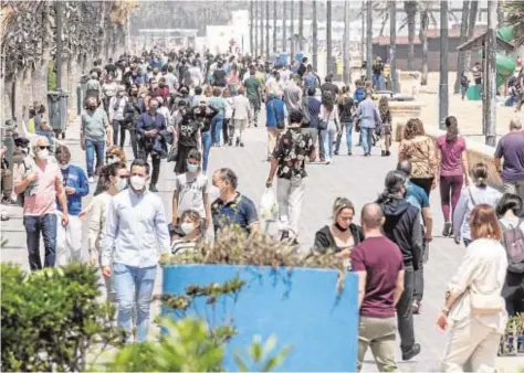  ?? MIKEL PONCE ?? Miles de personas caminan por el paseo marítimo de Valencia tras el fin del estado de alarma