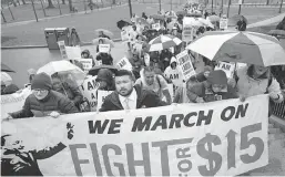  ?? Associated Press ?? n Demonstrat­ors carry signs and shout slogans Tuesday during a protest y in Boston, held to voice their concerns about racism and call attention to low wages. Tuesday was the 49th anniversar­y of the assassinat­ion of civil rights leader Martin Luther...