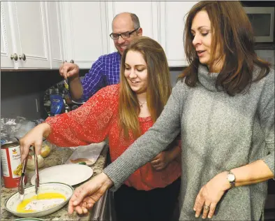  ?? Erik Trautmann / Hearst Connecticu­t Media ?? Ally Kernan, 27, left, who is recovering from opioid addiction, with her dad and mom, Michael and Sarah Massa, March 28 at their home in Fairfield. Below, Kernan holds mug shot photos of herself from 2012 and 2013.