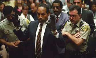  ?? (Sam Mircovich/Reuters) ?? O.J. SIMPSON wearing the infamous gloves during the Simpson double-murder trial in 1995 in Los Angeles.