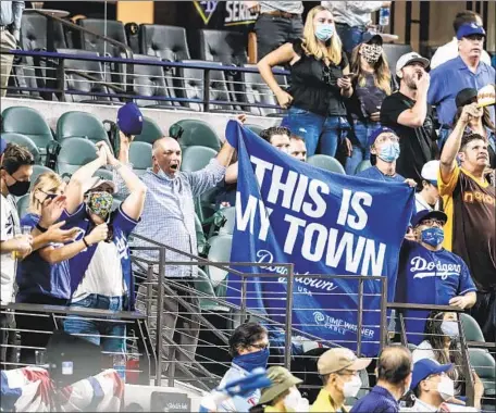  ?? SOME DODGERS Robert Gauthier Los Angeles Times ?? fans who went to Texas, like the ones above, said the pandemic- restricted celebratio­n would be offset by a Series win.