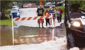 ?? Karen Warren / Houston Chronicle ?? Residents of a Richmond neighborho­od watch the water rise Monday as the Brazos River reached a record level.