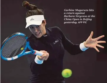  ??  ?? Garbine Muguruza hits a return against Barbora Strycova at the China Open in Beijing yesterday.