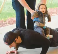  ?? ?? Connor Hoekstra, 10 months, joins Monee police Officer Stephen Crescenti for some of Crescenti’s 617 pushups in honor of fallen officers.