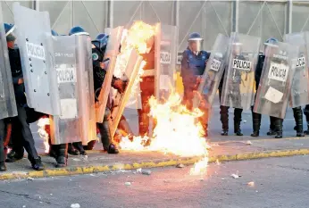  ??  ?? Cuando los policías llegaron a la zona para contener la protesta, fueron atacados por al menos 30 jóvenes encapuchad­os que comenzaron a lanzar bombas molotov y bengalas.