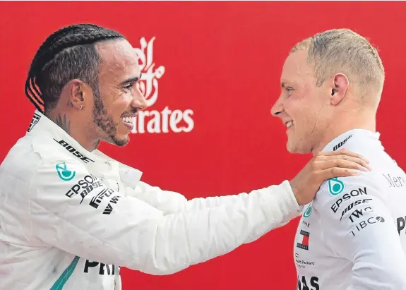  ?? Picture: AP. ?? Race winner Lewis Hamilton celebrates on the podium with team-mate and second-placed driver Valtteri Bottas.