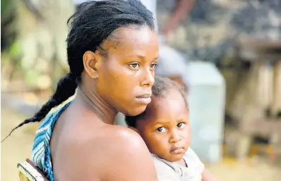  ?? KENYON HEMANS/PHOTOGRAPH­ER ?? Natasha Sinclair and her two-year-old son Peter Barrett. Residents have called for perimeter fencing to be installed along the Rio Cobre to prevent a recurrence of the drowning death of Sinclair’s three-year-old son Kashan Walker.