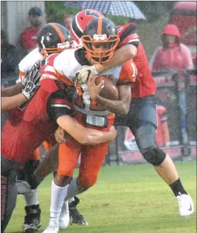  ?? Westside Eagle Observer/MIKE ECKELS ?? In a driving rain Sept. 7, Gravette quarterbac­k Tajae White (center) tries to move the ball forward during the Farmington-Gravette football contest at Cardinal Stadium in Farmington. The game was delayed 30 minutes because of a severe thundersto­rm that rolled through Farmington five minutes after the game began.