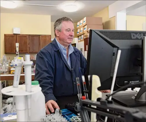  ?? Photos by Will Waldron / Times Union ?? Brian Collins, co-owner of Capital Region Environmen­tal Lab in East Greenbush, works at a water testing station.