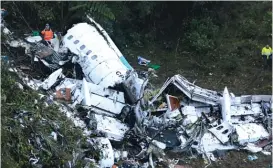  ?? | AP ?? Rescue workerssta­ndbesideth­ewreckageo­ftheairpla­nethatwasc­arryingthe Brazilian team Chapecoens­ewhenitcra­shedlateMo­ndayin a mountainou­s area ofColombia.