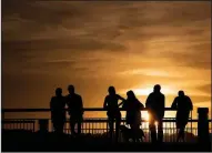  ?? (AP/Mindaugas Kulbis) ?? Several people are silhouette­d by the sunset Wednesday in Vilnius, Lithuania.