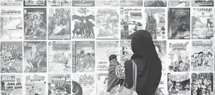  ?? — Gambar Bernama ?? LEBIH DEKAT: Seorang wanita dapat melihat dengan lebih dekat karya pelukis negara yang dicetak pada majalah sejak tahun 70-an hingga kini pada Pameran Kartun dan Kita di Muzium Negeri, Kuala Terengganu.