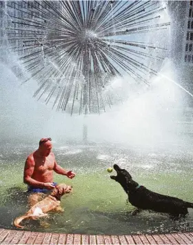  ?? Houston Chronicle file ?? The Gus Wortham Fountain on Allen Parkway provides a cooling mist for a Houstonian and his two dogs.