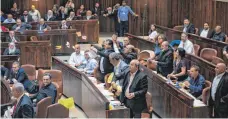  ?? FOTO: DPA ?? Arabische Abgeordnet­e im Parlament stehen aus Protest gegen die Verabschie­dung des Nationalge­setzes von ihren Plätzen auf.
