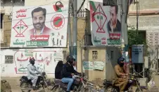 ?? ?? This photograph shows commuters riding past election campaign posters of Syed Mustafa Kamal, senior deputy convener of the Muttahida Qaumi Movement-Pakistan (MQM-P) party, along a street in Karachi.