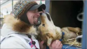  ?? MICHAEL DINNEEN — THE ASSOCIATED PRESS ?? Rookie musher Matt Failor, of Willow, Alaska, gets friendly with Pantera, a female dog in his team, prior to the ceremonial start of the Iditarod Trail Sled Dog Race on Saturday in Anchorage, Alaska.