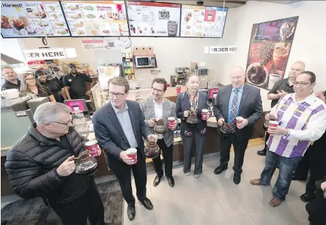  ?? TROY FLEECE ?? Sakimay First Nation Chief Lynn Acoose, fourth from left, pours coffee at the Saulteaux Crossing Business Park Esso Gas and Convenienc­e Store just west of Regina. Acoose says opening the first band-owned Tim Hortons in the Regina area is the...