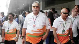  ?? — AFP ?? NEW DELHI: This file photograph shows then Force India-Mercedes Team Principal and Chairman and CEO of India’s Kingfisher Airlines Vijay Mallya (center) as he walks in the paddock during the third practice session at the Buddh Internatio­nal circuit in...