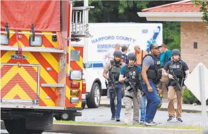  ?? MATT BUTTON / BALTIMORE SUN MEDIA GROUP ?? ATF police officers make their way to the scene of Thursday morning’s shooting at a Rite Aid distributi­on center in Perryman, near Aberdeen. Four people, including the shooter, were killed; three others were injured.