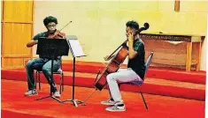  ?? [PHOTO BY CARLA HINTON, THE OKLAHOMAN] ?? Am’re Ford, founder of Arts in Action, left, performs a strings duet with Tayvion Devereaux during an Arts in Action recital at Quayle United Methodist Church, 5001 N Everest.