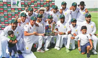  ?? AP ?? Pakistan’s jubiiant team hold the trophy after they beat Australia with a day to spare in the second Test match in Abu Dhabi to claim the series.