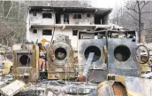  ?? ERIK SCHELZIG/ASSOCIATED PRESS ?? The remains of laundry machines sit on the site of a burned inn near downtown Gatlinburg, Tennessee. The resort town reopened to the public Friday for the first time since wildfires on Nov. 28.