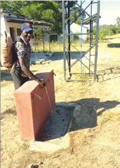  ?? ?? Magondo village head, Mr Revai Magondo gets a feel of the piped from a solarised borehole drilled by Minister Muswere at Gwangwadza Business Centre in Makoni West