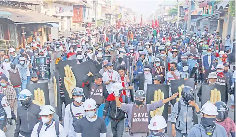  ?? — AFP photo ?? Protesters holding signs while taking part in a demonstrat­ion against the military coup in Dawei, capital of the Taninthary­i Region.