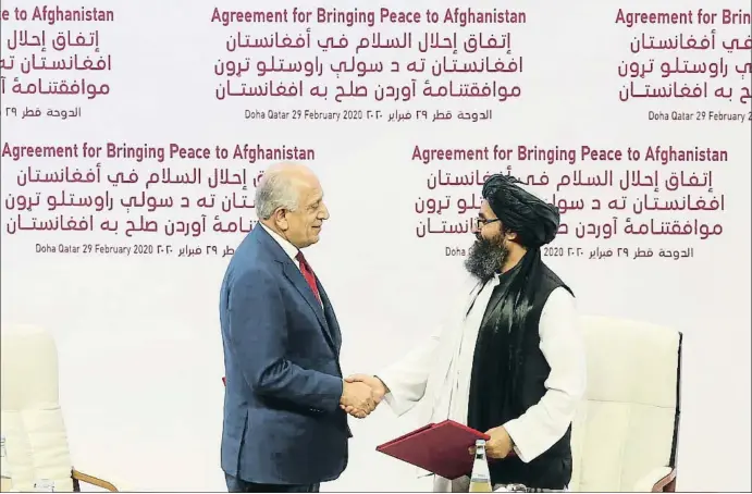  ?? HUSSEIN SAYED / AP ?? El enviado especial de Estados Unidos, Zalmay Jalilzad, y el segundo líder de los talibanes, el ulema Abdul Gani Baradar, sellan la paz en Doha (Qatar)