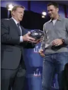  ?? DAVID J. PHILLIP, THE ASSOCIATED PRESS ?? NFL commission­er Roger Goodell hands Brady his MVP trophy during a news conference Monday.