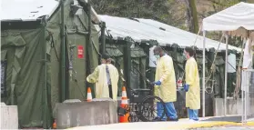  ?? FRANK GUNN / THE CANADIAN PRESS ?? Staff enter the mobile field hospital at Sunnybrook Hospital in Toronto on Tuesday. After graduating medical school, doctors in Canada must complete practical training of two years for family doctors and five for specialist­s.