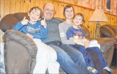  ?? NIKKI SULLIVAN/CAPE BRETON POST ?? Janine Parsons, a cancer survivor, sits with her family at her Sydney River home. On her lap is her four-year-old son, Matthew Thorne, next to her is her partner, Shaun Thorne, and their oldest, Travis, 8, sits next to him. Parsons was able to do all...