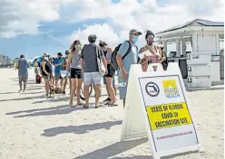  ?? David Santiago, Miami Herald via The Associated Press ?? People line up to receive the Johnson & Johnson vaccine at the one-time, pop-up vaccinatio­n site on the sand on Sunday in Miami Beach.