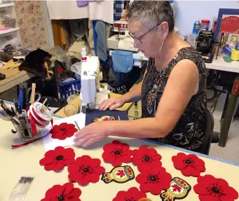  ??  ?? Clockwise from top: One of Ava’s quilt panels; close-ups of the handmade poppies and squares with crest and embroidere­d name; Ava at work.