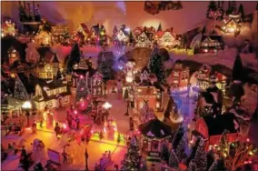  ?? PAUL POST -- PPOST@DIGITALFIR­STMEDIA.COM ?? A lighted Christmas village with dozens of houses and buildings is one of many features visitors may see at the Smith residence, 22 Clayton St., in Glens Falls.