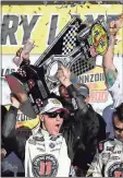  ?? Isaac Brekken / AP ?? Kevin Harvick hoists the trophy with his team after winning in Las Vegas.