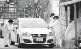  ??  ?? FORENSIC investigat­ors inspect a car outside Mota’s home in Temixco, a gritty suburb of 115,000 adjacent to the picturesqu­e tourist haven of Cuernavaca.