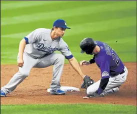  ?? Andy Cross / The Denver Post ?? Los Angeles Dodgers shortstop Corey Seager (5) tags Colorado Rockies shortstop Trevor Story (27) who was caught stealing second base in the first inning at Coors Field Sept. 18, 2020.