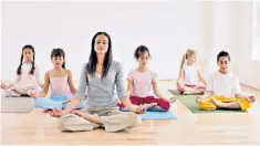  ??  ?? Calm and happy: teachers are using yoga to help expand children’s attention spans